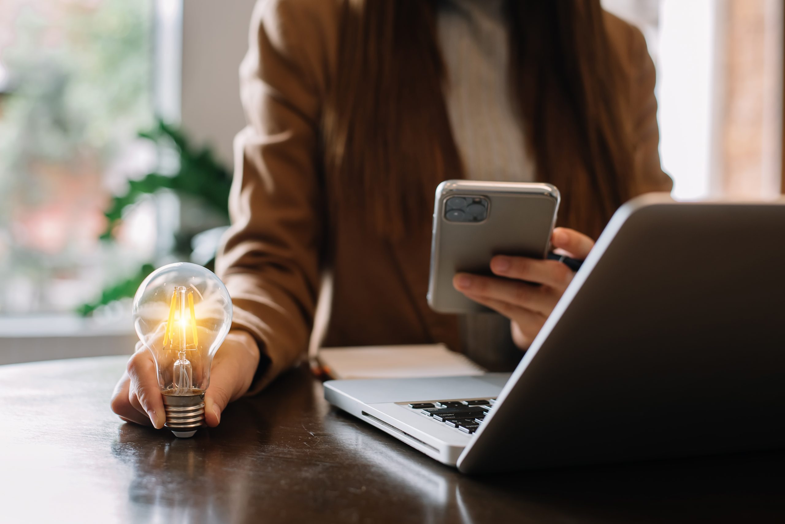 Businesswoman holding and putting lightbulb on coins stack on table for saving energy and money concept
Idea saving energy and accounting finance concept